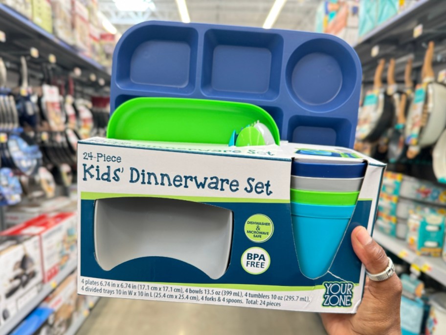 hand holding a kid's 24 pc dinnerware set that has brightly colored plates, cups and bowls