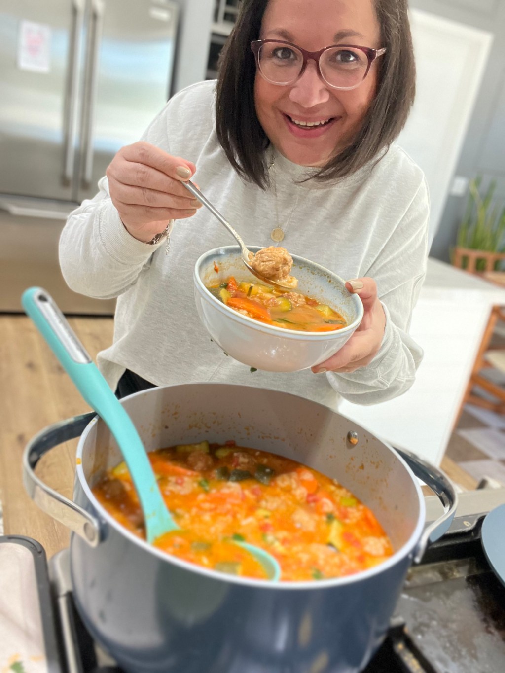 woman holding a bowl of mexican meatball soup