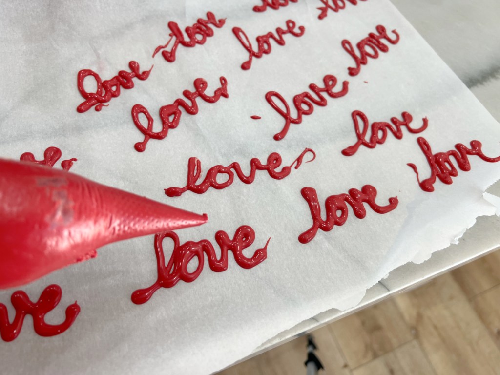 writing love with candy melts on parchment paper