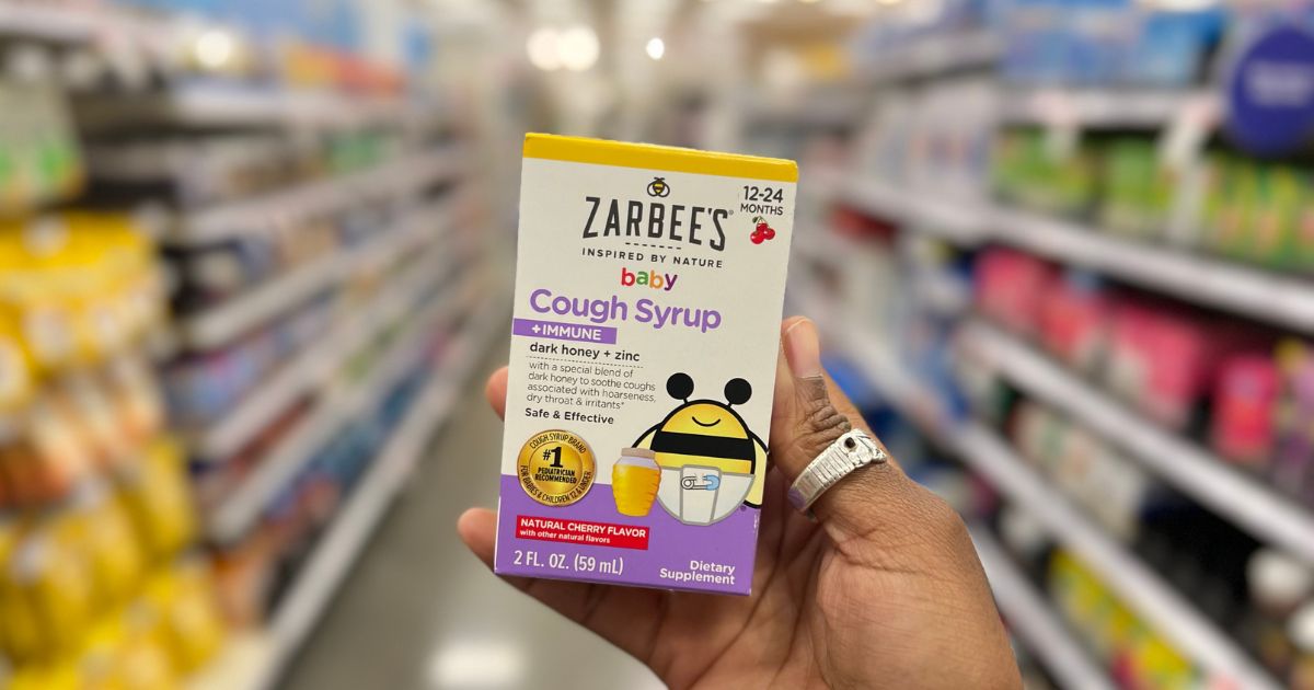 a womans hand holding zarbees baby cough on a store aisle