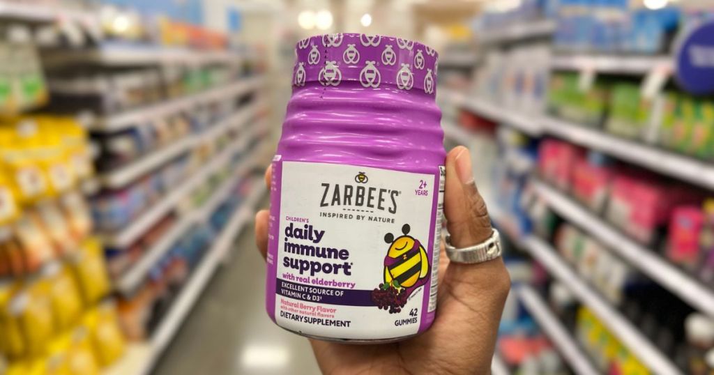 a womans hand holding zarbees daaily immune support on a store aisle