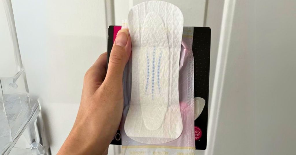 hand holding a box and open individual U by Kotex barely there balance panty liner