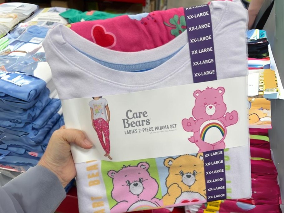 person's hand holding a women's Care Bears Pajama set in store