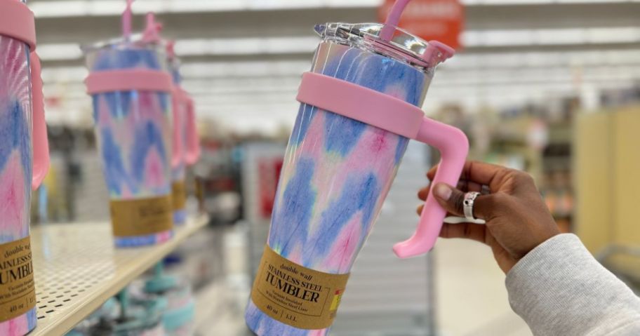 hand holding up a pink and blue stainless steel 40 oz tumbler with handle at Hobby Lobby