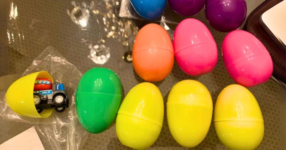 colorful plastic easter eggs with 1 open showing construction vehicle toy inside