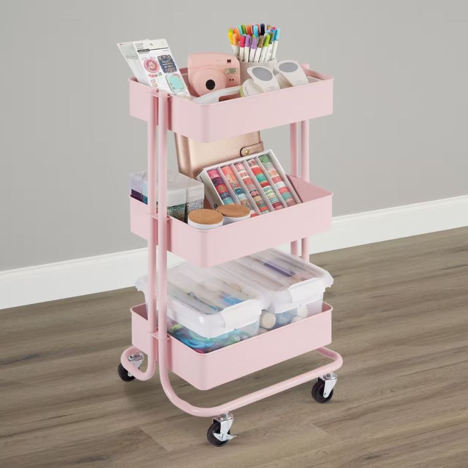 pink 3 tier metal rolling cart with craft supplies on it