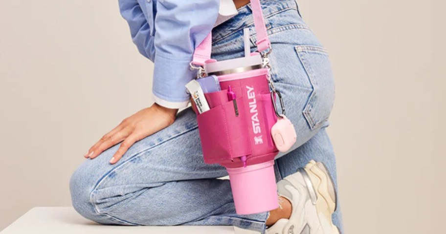 woman wearing jeans and a jean jacket with a hot pink and light pink Stanley Quencher Carryall with a pink Stanley tumbler in it