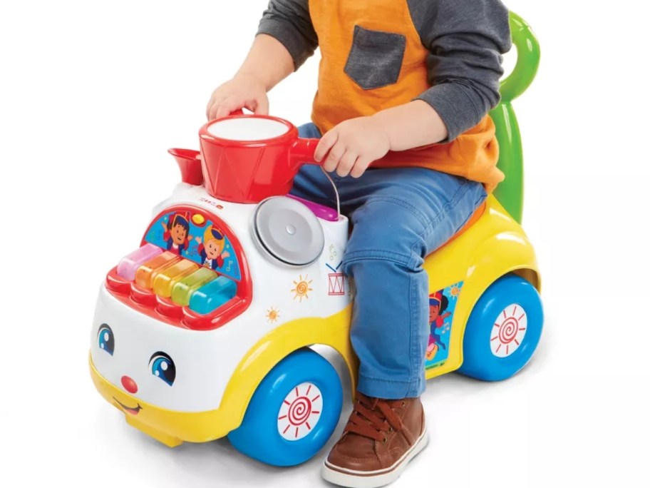 little boy on a primary color ride on toy