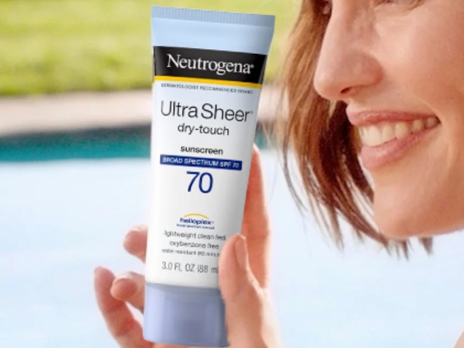 woman holding a bottle of Neutrogena Ultra Sheer Dry-Touch Sunscreen
