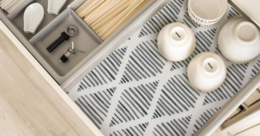 open kitchen drawer with grey pattern shelf liner and cutlery