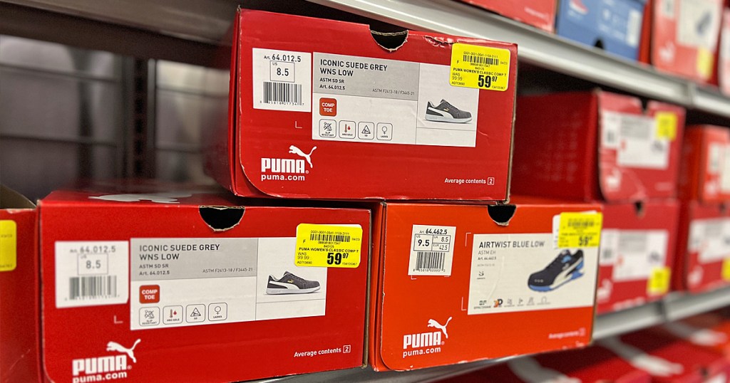 stacked red boxes of puma shoes on store shelf