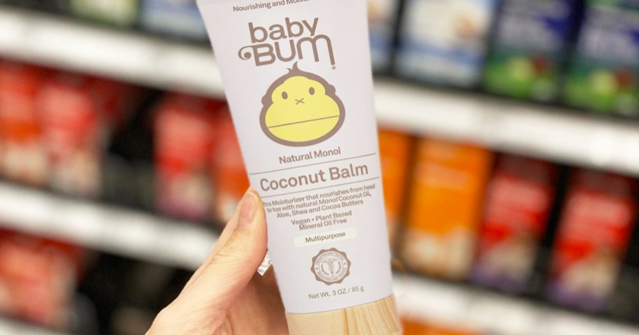 hand holding a tube of Baby Bum Monoi Coconut Baby Balm
