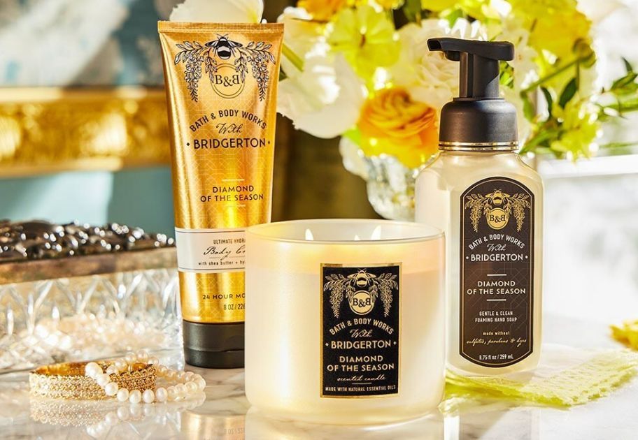 Bath and Body Works Bridgerton Collection with flowers on a desk