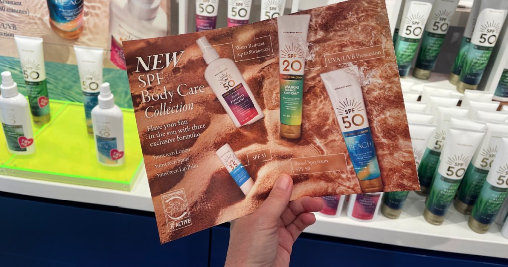 person holding bath & body works mailer in store