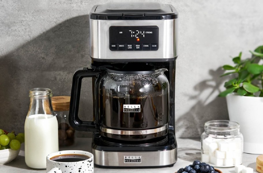 Bella coffee maker with drinks, milk and food around it