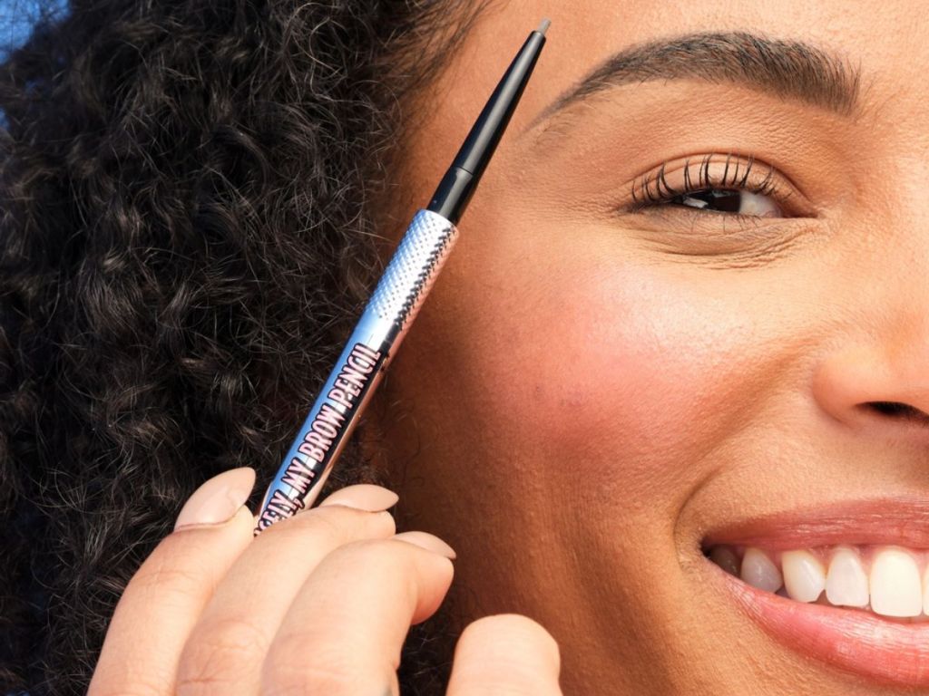 Woman using a Benefit Precisely my brow pencil to fill in her brows