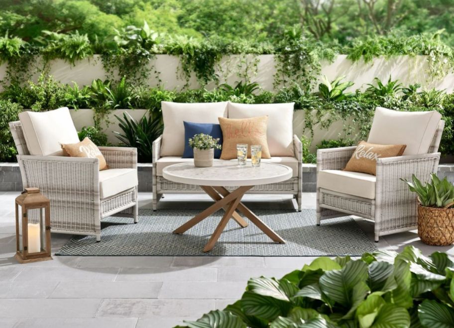 a white 4 piece wicker patio set with 2 chairs, love seat and table