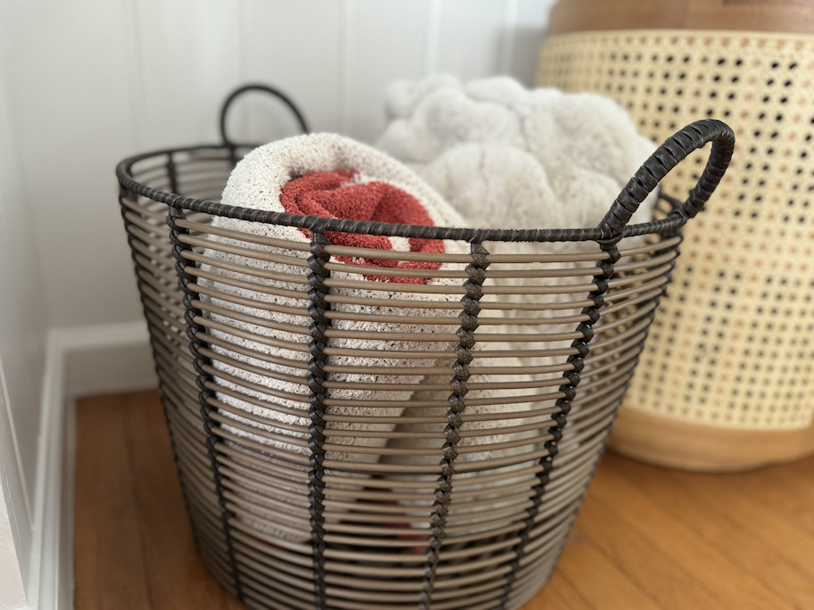 close up of wire basket with rolled up blankets inside