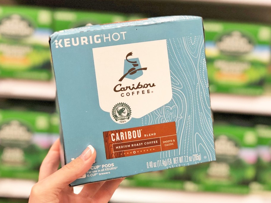 hand holding up a box of Caribou Coffee k-cups in store