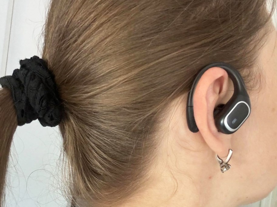 girl wearing black headphone that wraps around the back of her ear