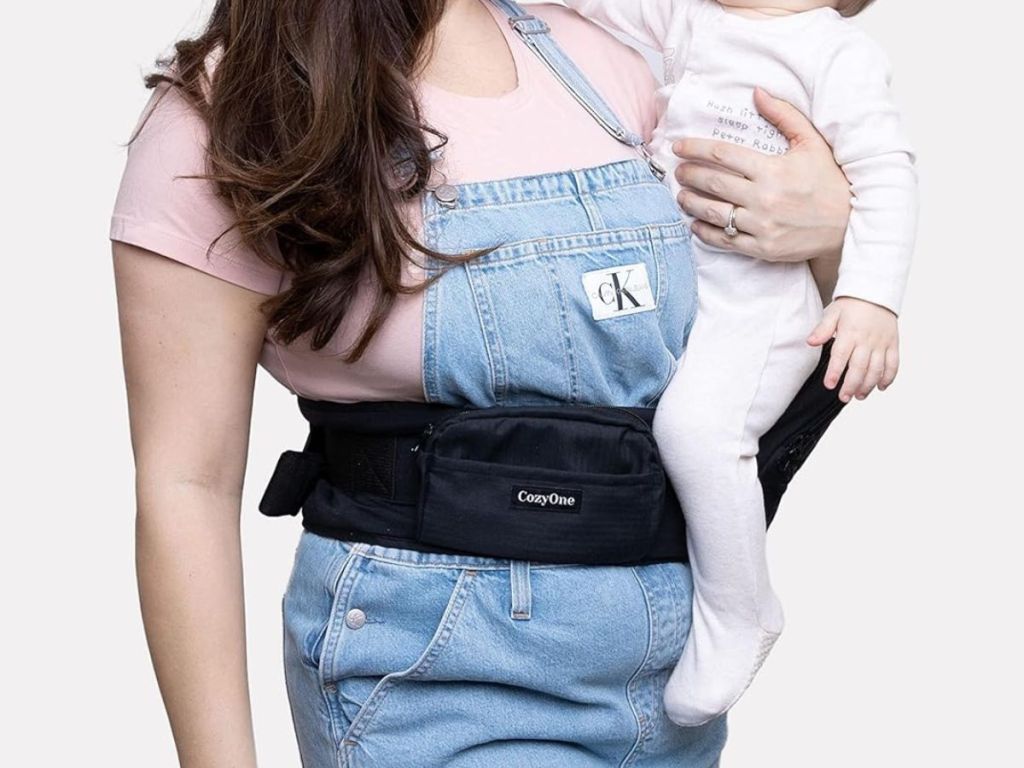 A woman wearing a CozyOne Baby Hip Carrier with a child