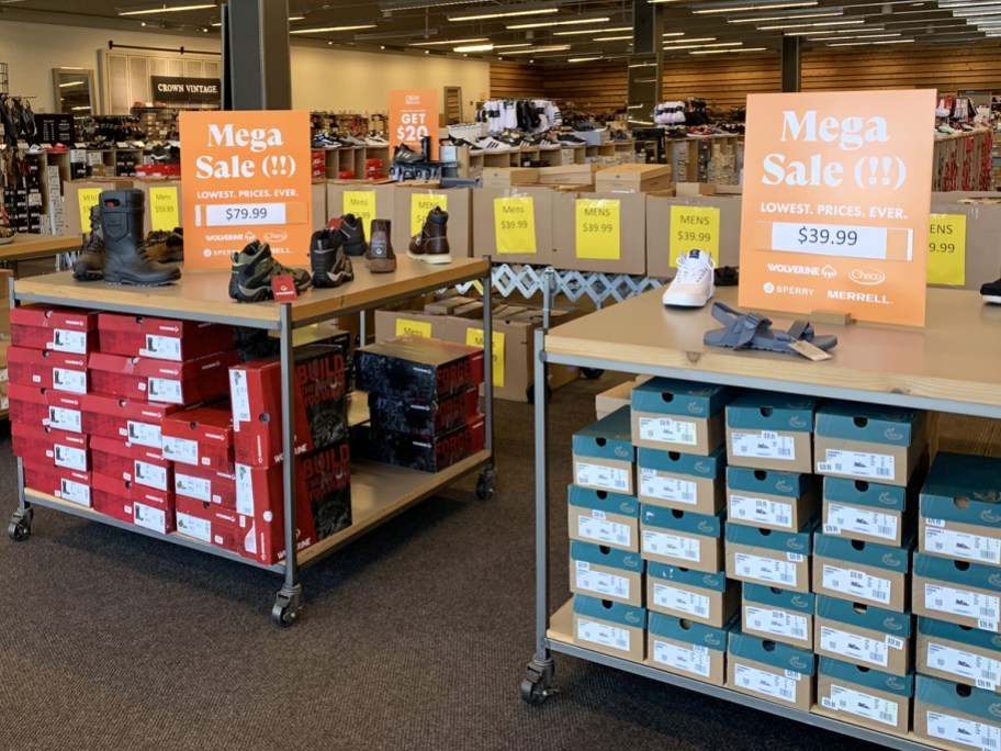 display tables full of shoes in dsw store with sale signs