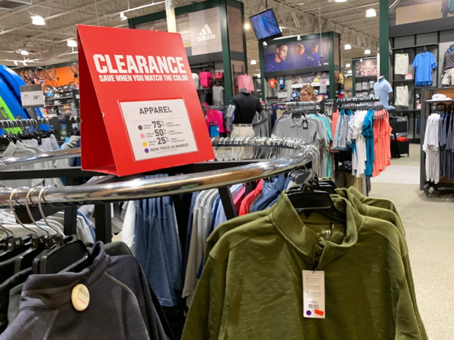 red clearance sign on top of rack of clothing in store