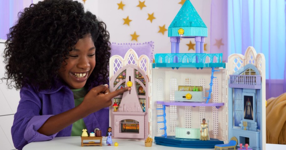 girl playing with a Disney Wish castle playset