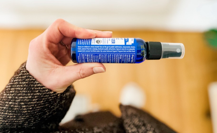 hand holding a bottle of dr. Bronner's organic peppermint hand sanitizer