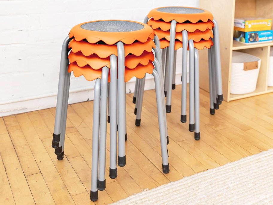 two stacks of orange and grey kids stools in classroom