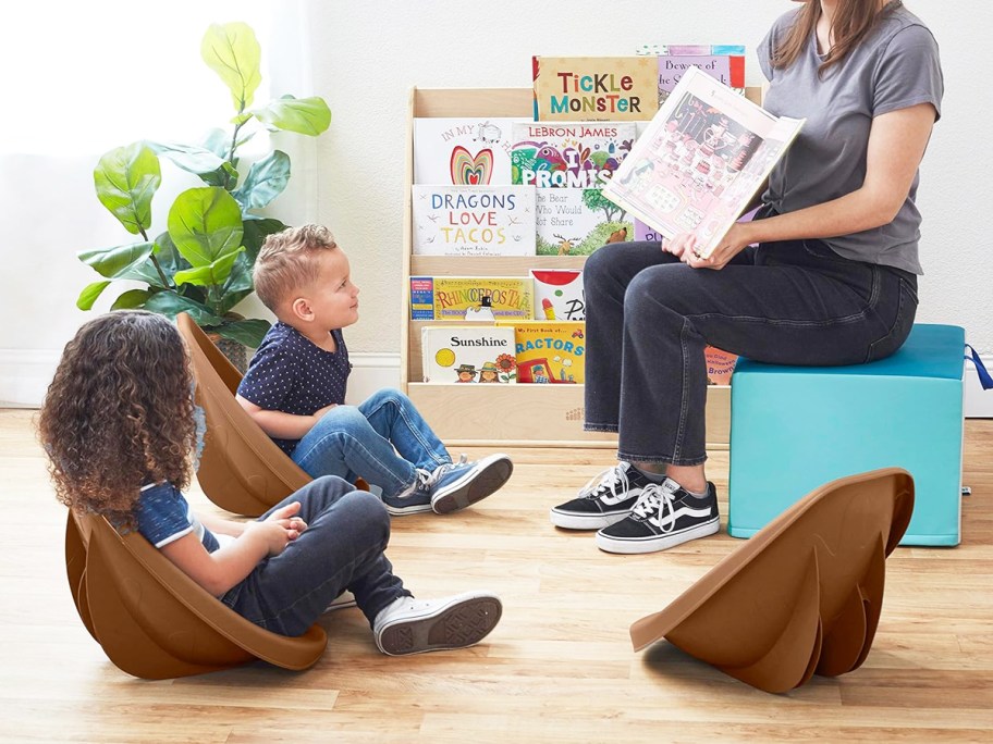 kids sitting in brown plastic rocker chairs at story time
