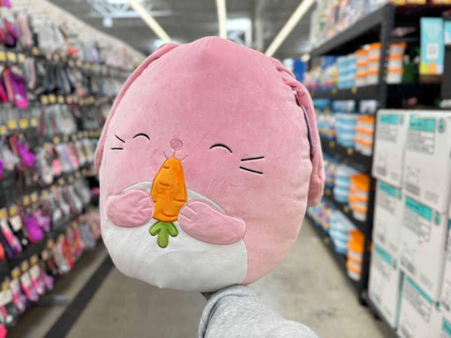 A hand holding an Easter Squishmallow Bunny at Walmart