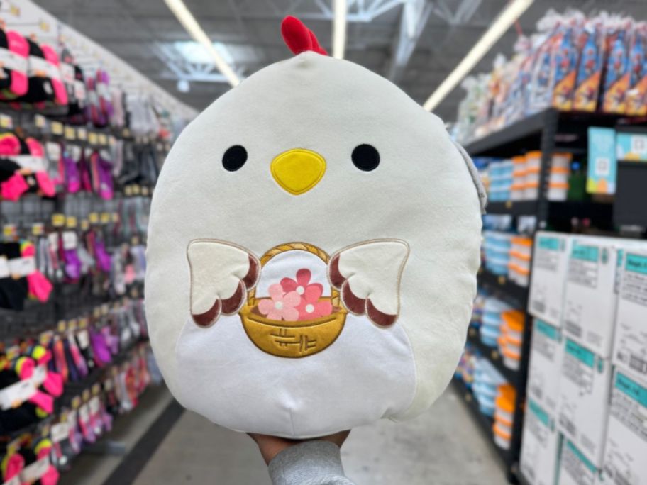 A hand holding an Easter Squishmallow Chicken at Walmart