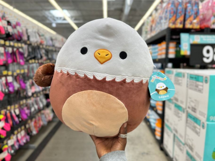 A hand holding an Easter Squishmallow Eagle at Walmart