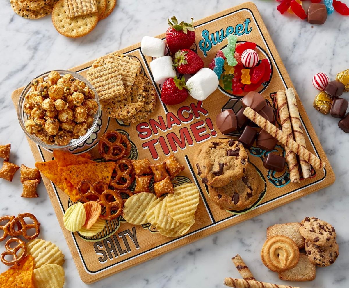 a large bamboo cutting board covered with tasty looking treats and snacks