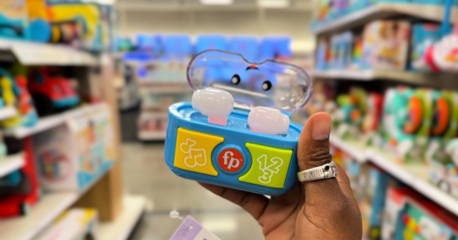 person holding up fisher price ear buds in store