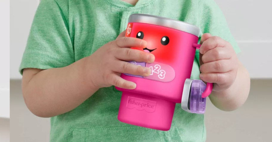 little boy holding fisher price pink coffee tumbler