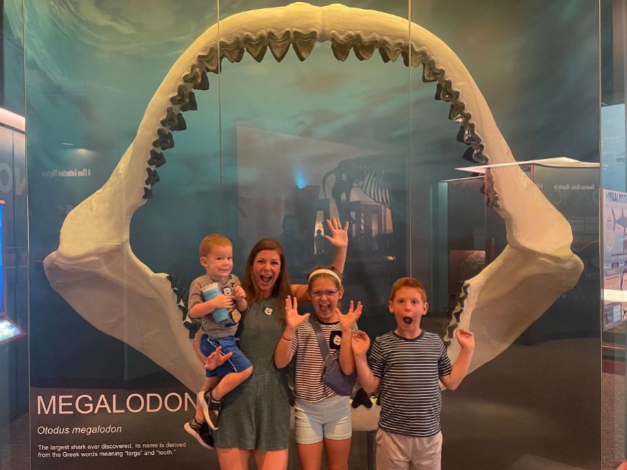 Family posing with skeleton of a Megalodon's mouth