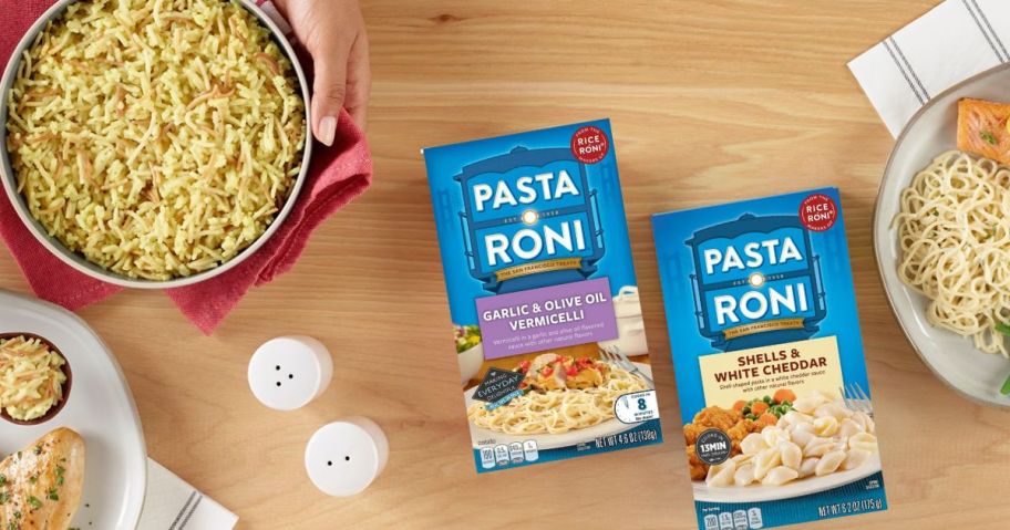 Pasta Roni boxes on table with pots of cooked Pasta Roni and plates with meals on them