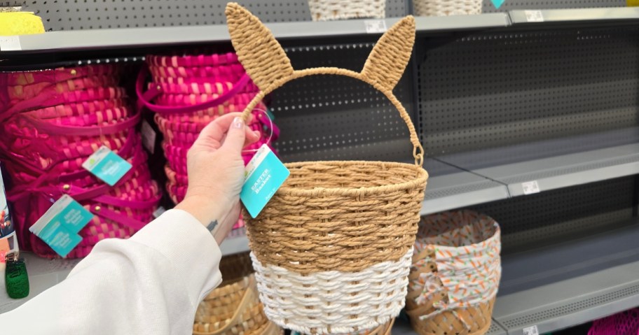 hand holding a natural brown and white easter basket with bunny ears in a store aisle