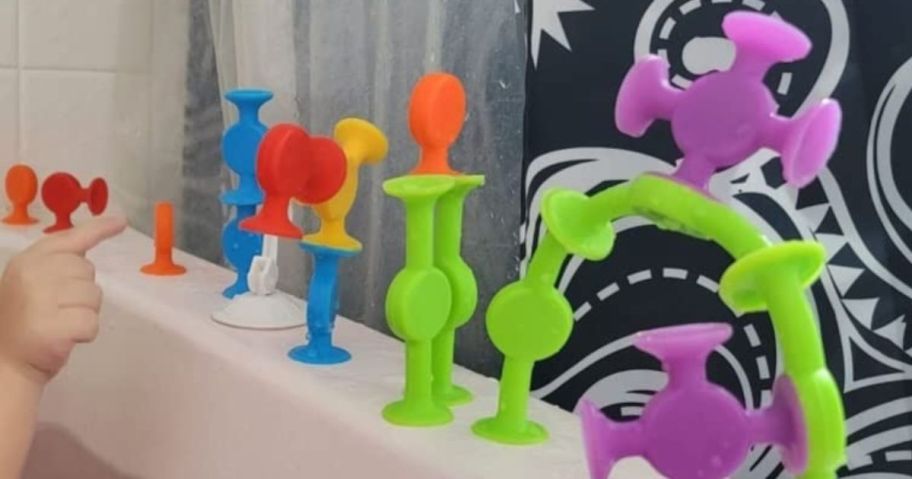 Bunmo textured sensory bath toys in bright colors shown on edge of bathtub