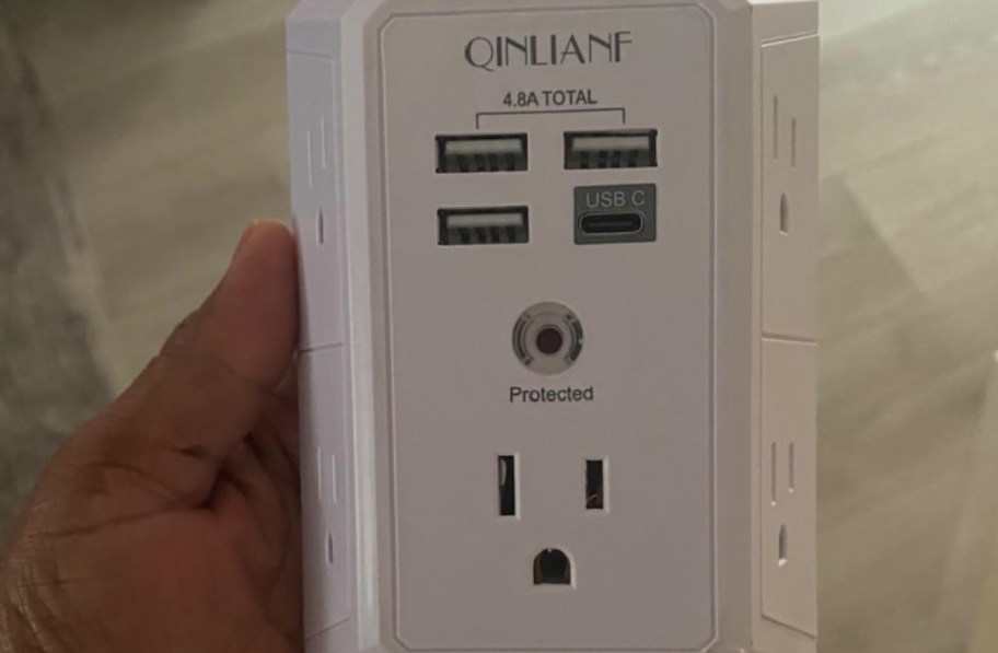 Hand holding outlet extender