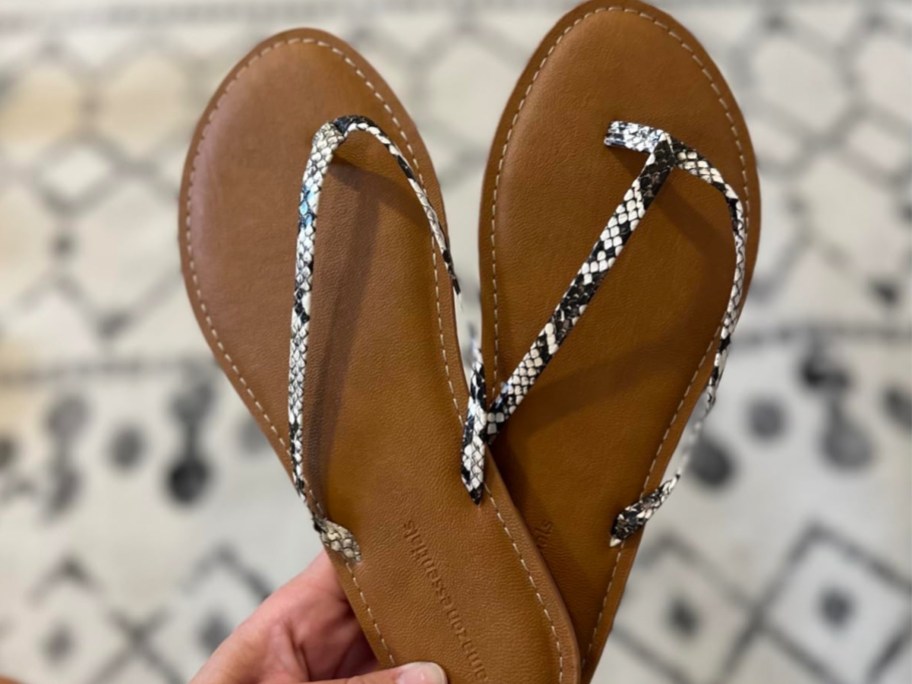 Hand holding thong sandals from amazon