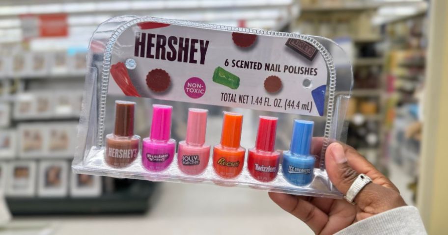 A hand holding a 6 pack of Hershey Scented Nail Polishes