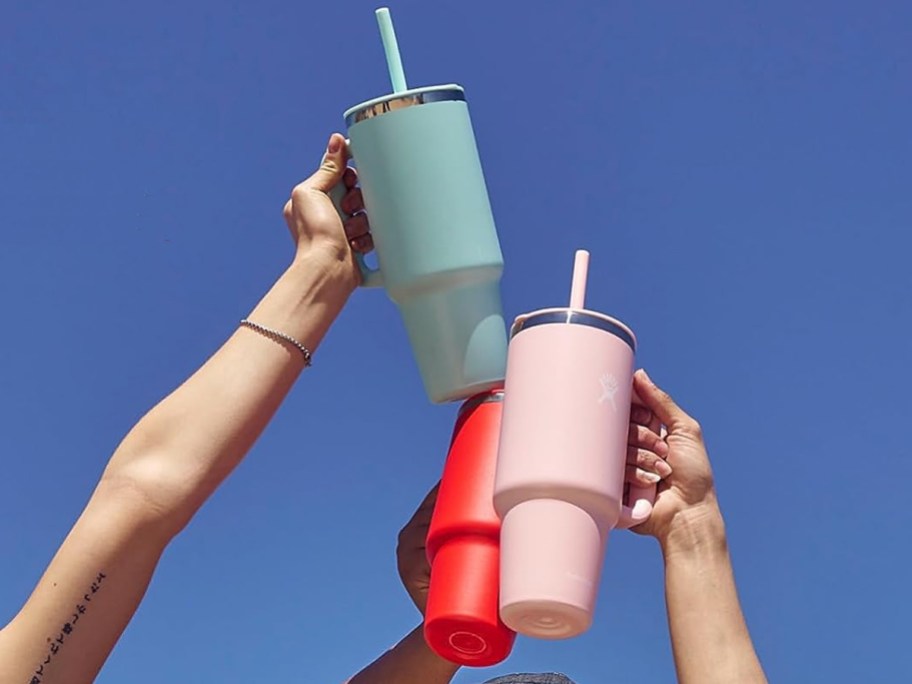 hands raising up 3 Hydro Flask all around tumblers
