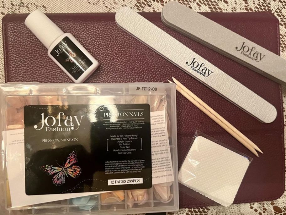 A jofay nail kit with nail glue, 2 files, 2 cuticle pushers, and nail pads.