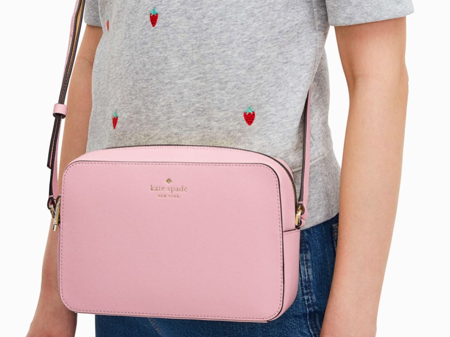 woman in strawberry print top with large pink crossbody bag