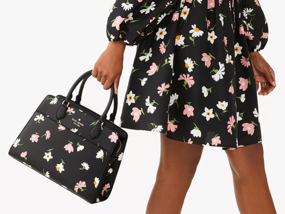 woman in black floral print dress holding matching purse