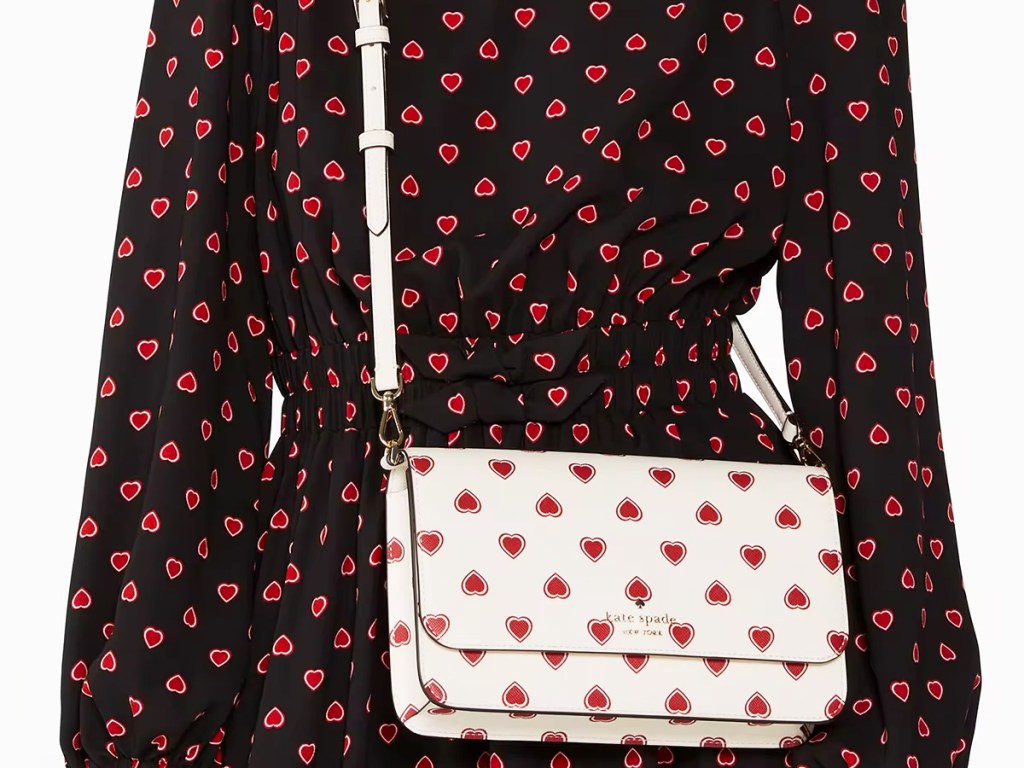 woman in black and red heart print dress with white and red heart print crossbody bag
