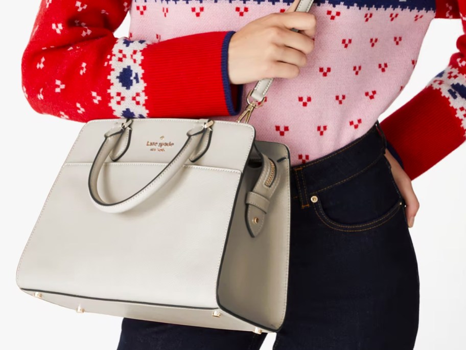 woman in sweater and black jeans with white purse